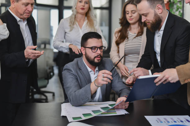 istock Employees Are Assisting CEO Showing Him Paperwork While He's Examining it Carefully 2195062669