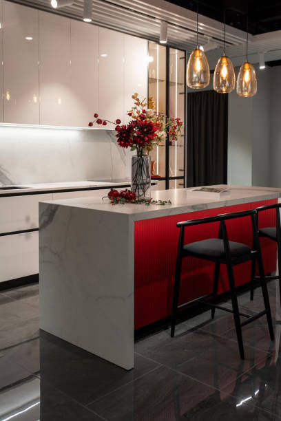 istock Sleek kitchen interior features a white and red island with decorative flowers 2195062700