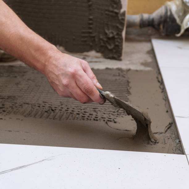 istock Construction worker applies cement for laying floor ceramic tiles with spatula 2195063998