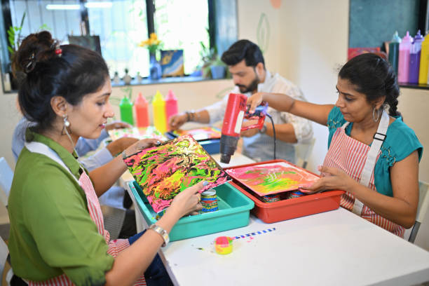 istock Creative fluid art workshop at an art studio with diverse participants engaged in colorful activities 2195065404