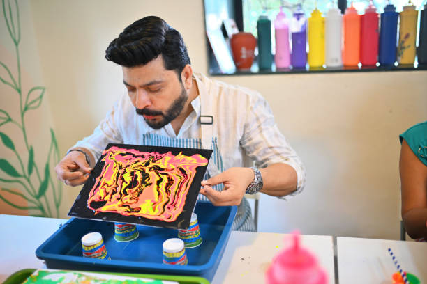 istock Mid-adult man experimenting with fluid art in an art workshop 2195065448
