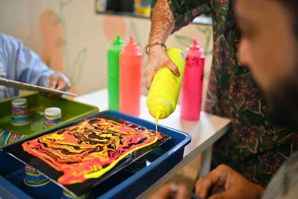 istock Cropped hands pouring vibrant Fluid colors during a fluid art workshop 2195065465