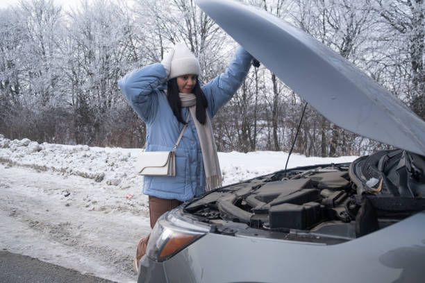 istock Woman watching at Car Engine on Snowy Roadside 2195070392
