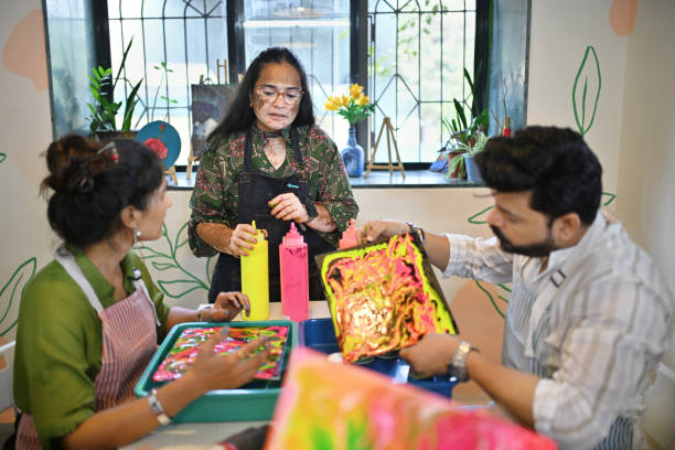 istock Passionate woman artisan explaining participants creative fluid art during an art workshop 2195071204