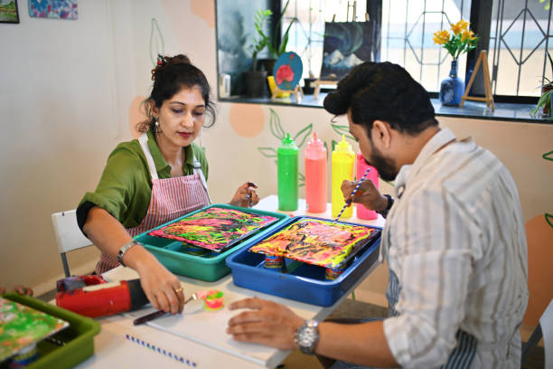 istock Mid-adult couple enjoying Creative Fluid art workshop at an Art studio 2195071211