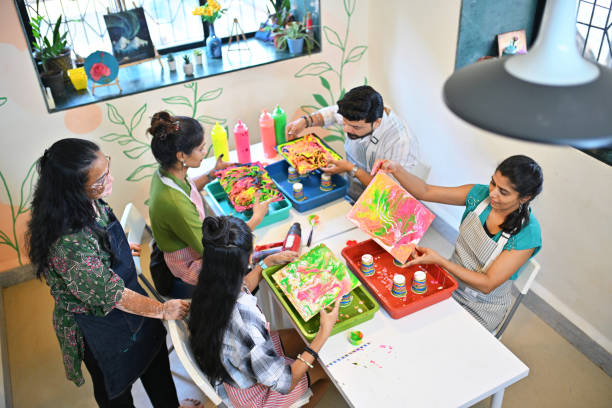 High angle shot of a Creative fluid art session at an art workshop with diverse participants engaged in colorful activities