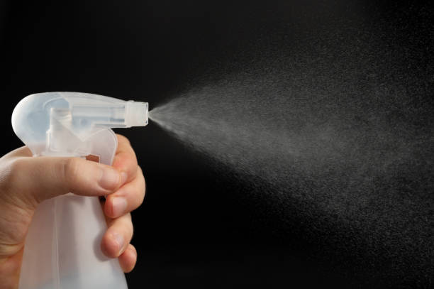 istock Close up of bottle in hand with spray cloud 2195074759