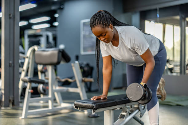 istock Woman Exercising With Dumbbells in a Modern Gym Environment 2195078522
