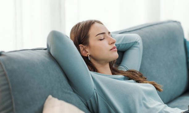istock Relaxed young woman napping on the couch 2195082307