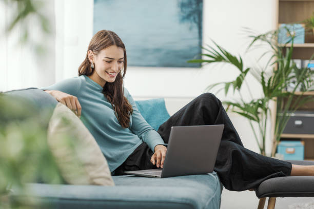 Young woman relaxing on the couch and using a laptop
