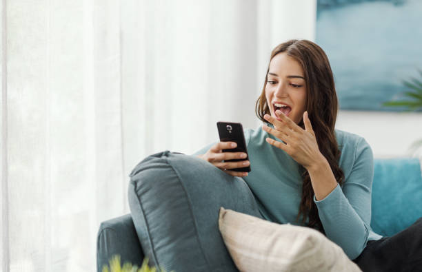 istock Cheerful surprised woman connecting with her smartphone 2195085499