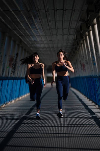 istock Two athletes running together under a bridge, showcasing synchronized motion and determination 2195085515