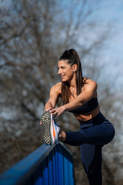 istock Smiling athlete stretching leg on railing outdoors, sunny day reflecting healthy routine 2195085569