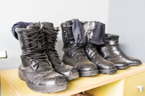 A row of leather combat boots lined up on a shelf, representing discipline