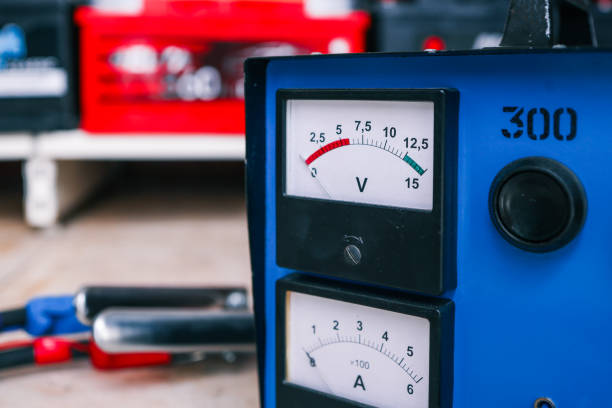 istock Close-up of a blue charging station featuring analog voltage and amperage meters with calibration markings. Professional industrial equipment for power monitoring 2195086549