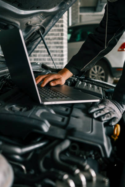 istock A mechanic using a laptop on a car engine for diagnostics in a garage. Highlights the use of technology in modern vehicle maintenance and repair 2195086643