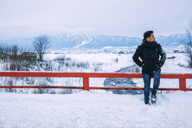 Asian man standing in the snow
