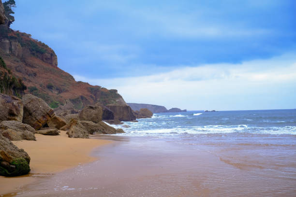 istock A rocky beach with a cloudy sky in the background. 2195087310