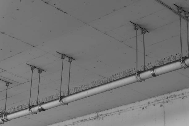 istock Metal pipe with spikes suspended from a ceiling in urban environment during the day 2195088920