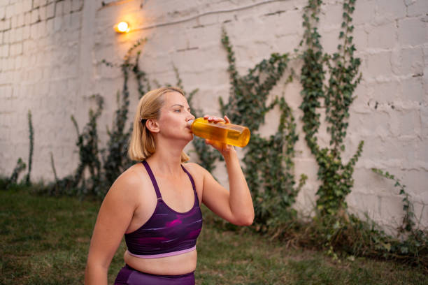 istock Fit woman drinking refreshing drink after home workout 2195091120