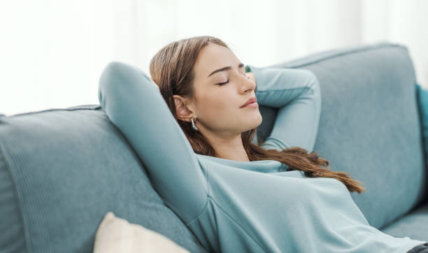 istock Relaxed young woman napping on the couch 2195091268