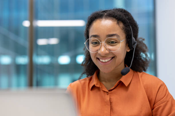 istock Smiling woman wearing headset while working remotely in a modern office environment 2195091524