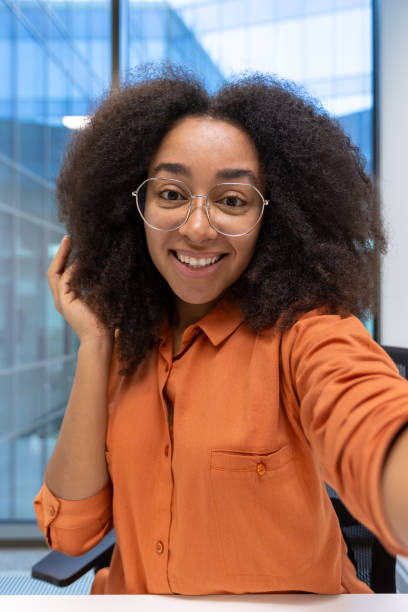 istock Smiling Young Woman Taking A Self-Portrait in a Modern Office Environment 2195091576