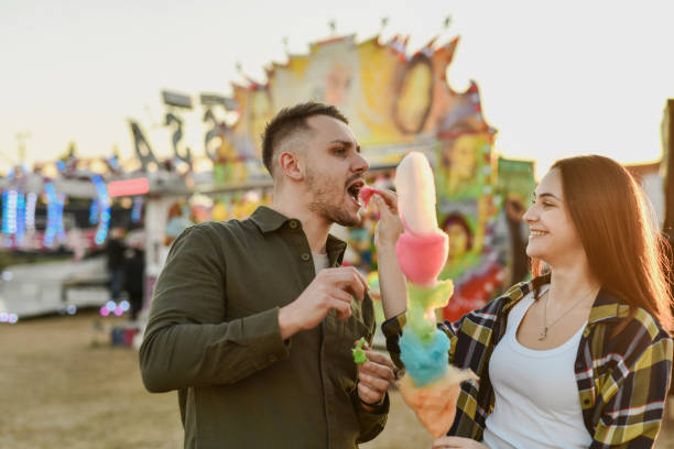 istock Boyfriend Indulging in Cotton Candy While He's Joyful Girlfriend is Feeding Him 2195092723