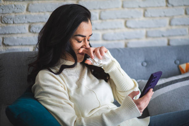 istock Sick woman resting on sofa at home and using smart phone 2195092741