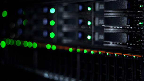 istock Close-up view of a data server rack with green indicator lights glowing in a dark room, representing data storage, IT infrastructure, and network management. 2195093142