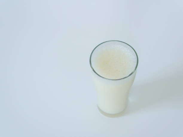 Lifestyle, Health care, Drinking milk in the morning. One hand holding a glass of milk to drink with a white background. White liquid in a clear glass. Benefits of drinking milk and calcium