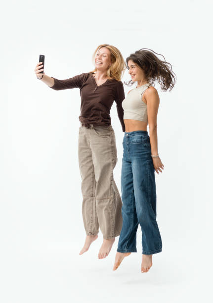 istock Happy young women using a smartphone and jumping 2195096048