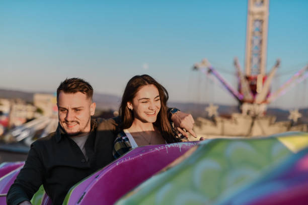 Handsome Boyfriend Embracing Girlfriend on Rollercoaster Ride While Both Smiling and Enjoying