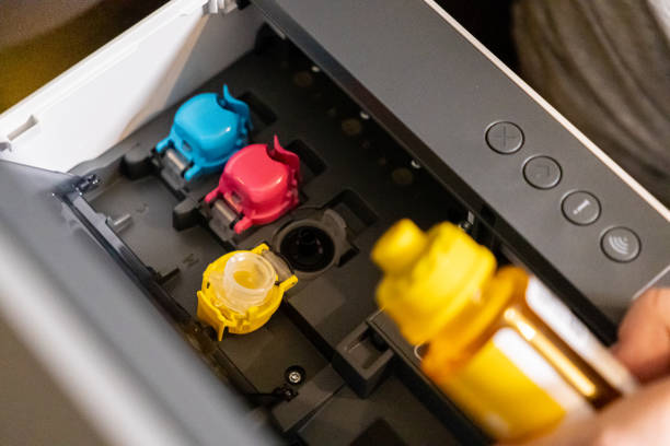 istock refilling ink tank in printer with focus on color cartridge compartments and yellow bottle 2195096814