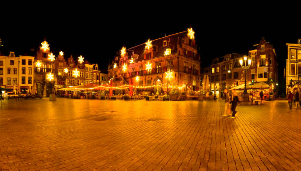 Grote Markt in Nijmegen, Gelderland, during a cold winter night with the ancient Waag building and the Stevenskerk in the background.