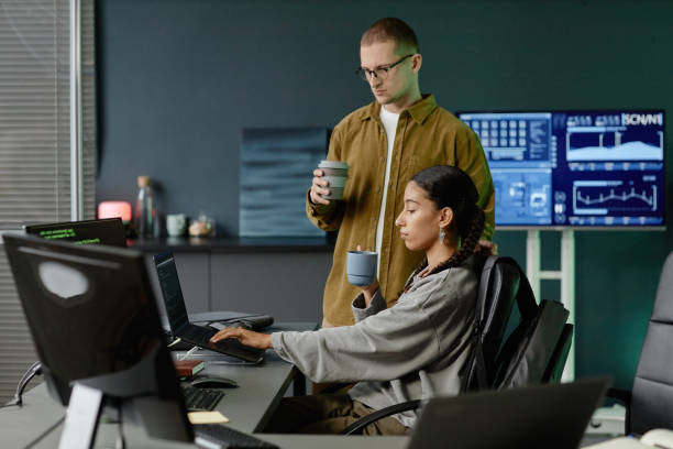 istock Female Programmer Using Laptop Collaborating with Male Colleague at Work Meeting in Office 2195099653
