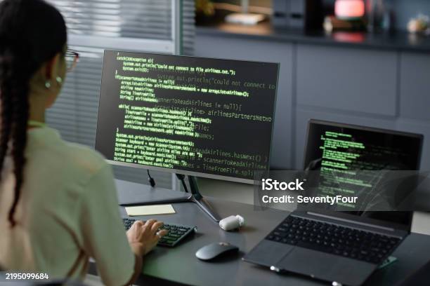 Female It Programmer Coding On Computers Using Multiple Screens At ...