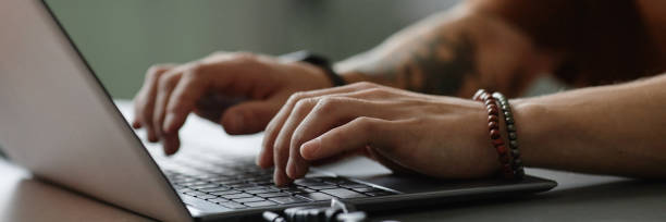 istock Header Image of Male Hands Typing on Keyboard of Laptop Working in Office 2195099982