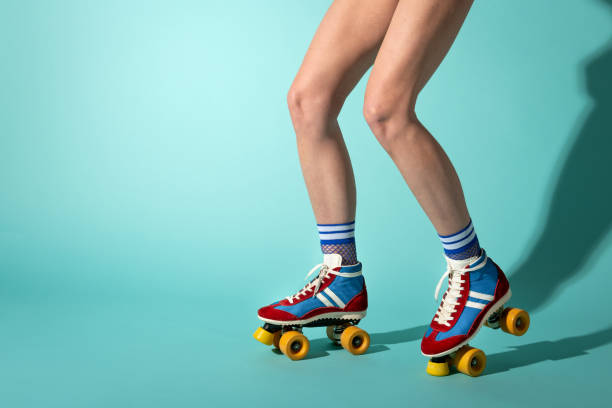 istock Woman wearing vintage roller skates posing on turquoise background 2195100697