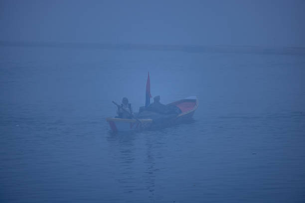 Fisherman in Tuyen Lam lake in a foggy morning, Da Lat city, Lam Dong province, central high lands Vietnam