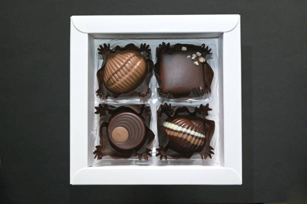 4 chocolate pralines in a square white box.