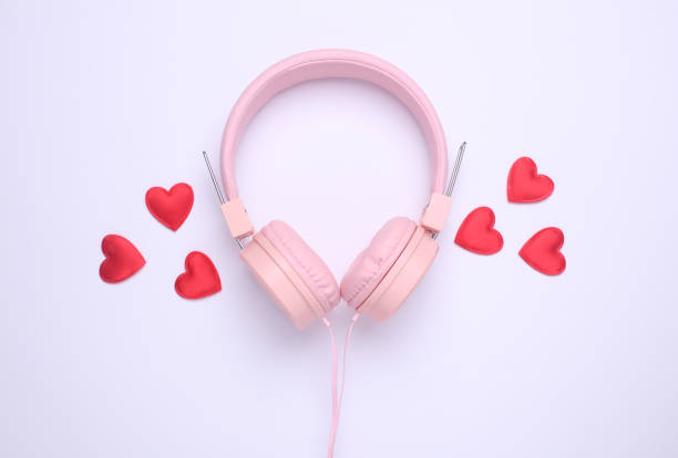 istock Wired stereo headphones with red hearts on white background. Top view 2195106728