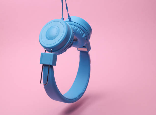 istock Floating blue stereo wired headphones on pink background 2195106732
