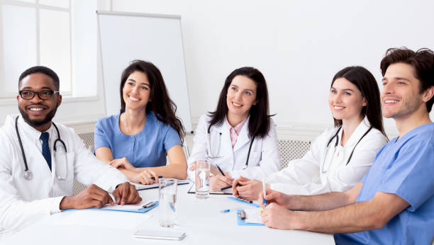 istock Young interns listening to professor in conference room 2195107768