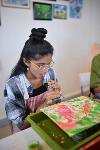 istock Young girl crafting fluid art using straw technique 2195107927