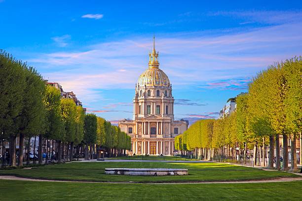 istock Les Invalides dome in Paris surrounded by trees and a colorful sky 2195109140