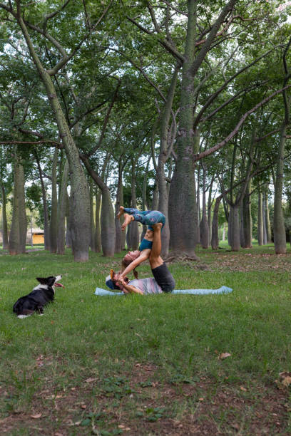 istock Focused couple practicing acroyoga in park in summer time 2195109238