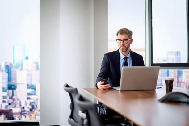 istock Executive businessman sitting in a modern office and working on his laptop 2195109387