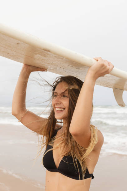 istock Surfer with surfboard on head on sea beach 2195110707