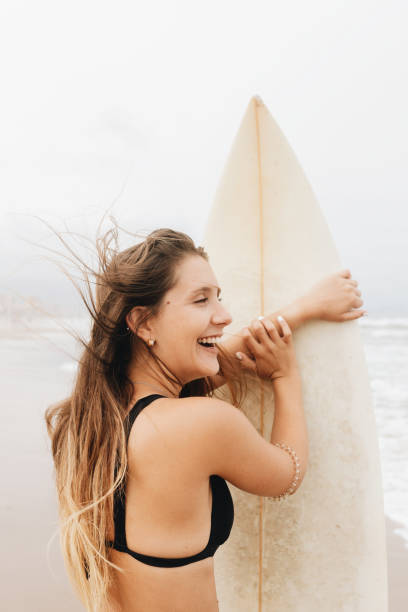 istock Happy surfer with surfboard on sea shore 2195110908